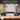 1 metre ruler with handle on a wooden surface, blurred background of people wearing safety vests.