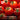Close-up of fresh tomatoes with a brand logo and text about seasonal growing.