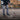 Person using reacher grabber as a litter picker on a concrete surface with a brick wall in the background